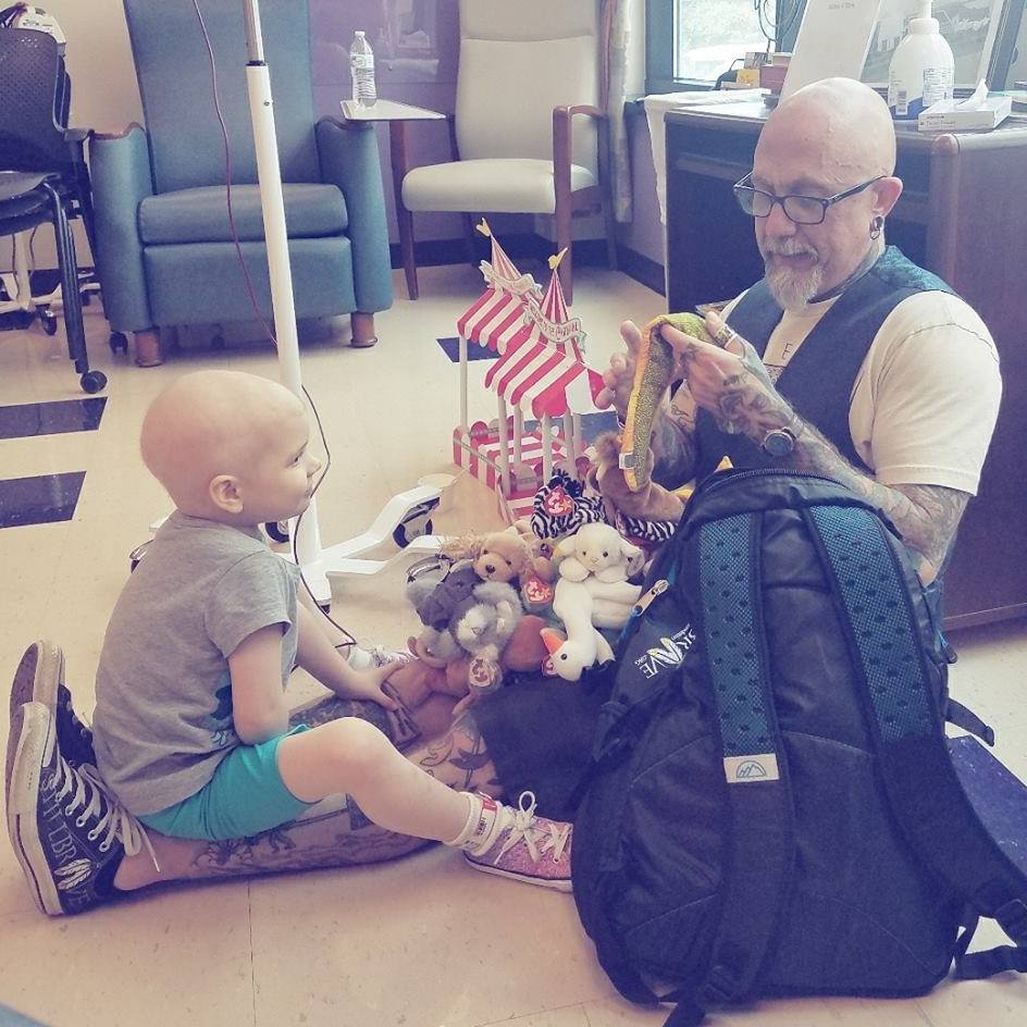 Tattoo Tom plays with a child in the hospital waiting room